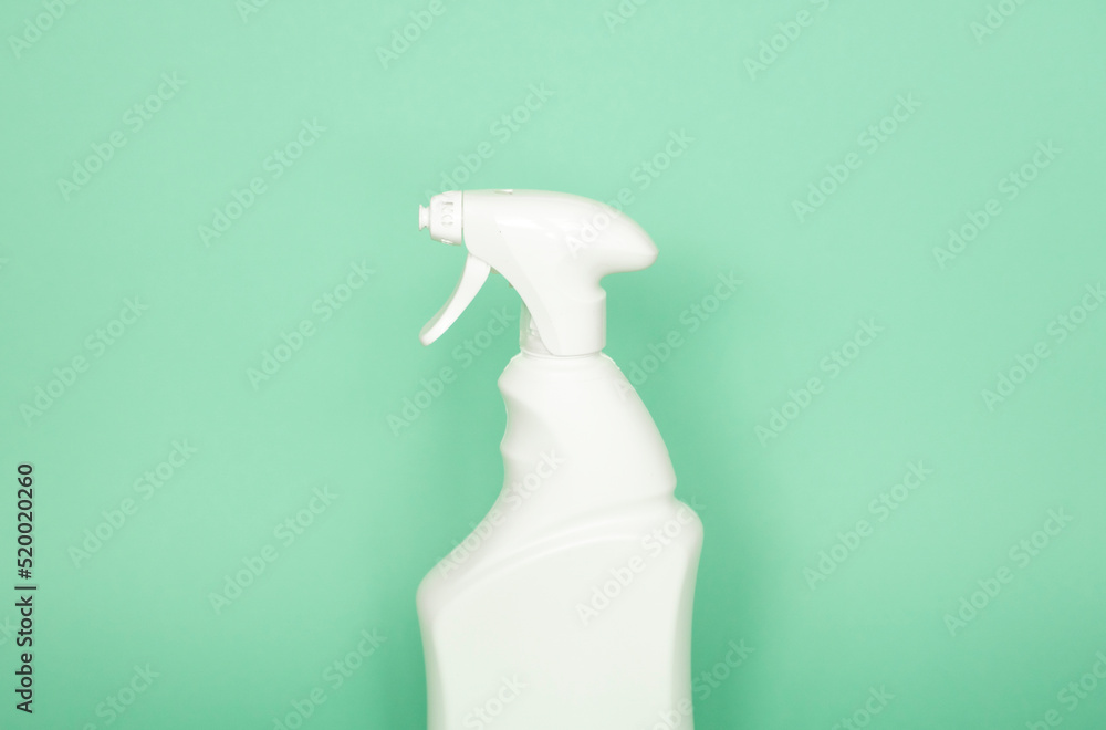 White plastic spray bottle for liquid cleaning products isolated on green background. Packaging mockup bottle with sprayer. White plastic spray bottle for liquid cleaning products isolated on green background. Packaging mockup bottle with sprayer.