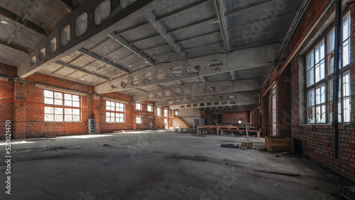 Abandoned industrial building with concrete trusses brick walls