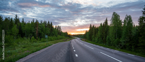 Fototapeta Naklejka Na Ścianę i Meble -  Winding road in forest at sunset
