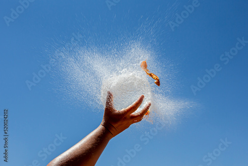Wallpaper Mural Water filled balloon explodes on a hand with the blue sky in the background. Childish games. refreshing games. Explosion of a balloon. Torontodigital.ca