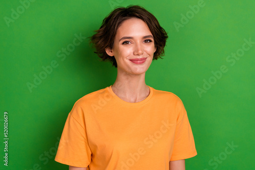 Photo of adorable charming young lady wear orange outfit smiling isolated green color background