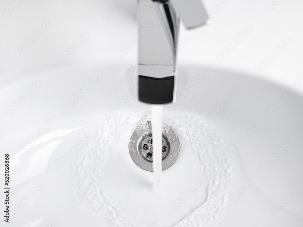 Water running from Faucet tap in white sink Water running from Faucet tap in white sink
