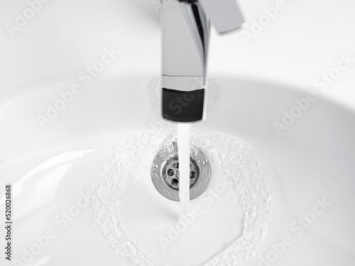 Water running from Faucet tap in white sink