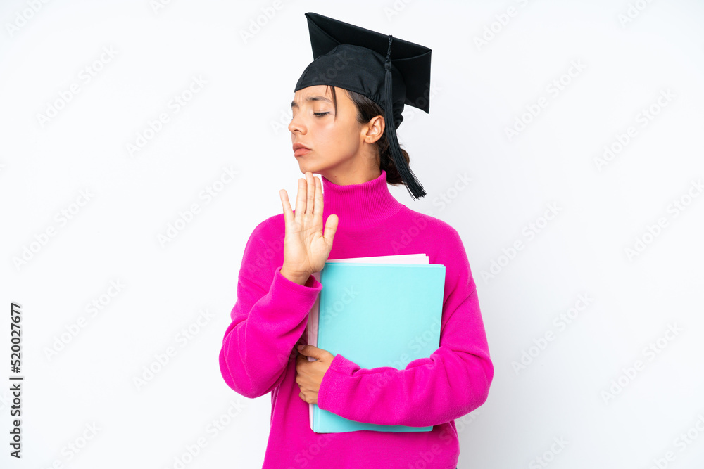 Young student hispanic woman holding a books isolated on white background making stop gesture and disappointed Young student hispanic woman holding a books isolated on white background making stop gesture and disappointed