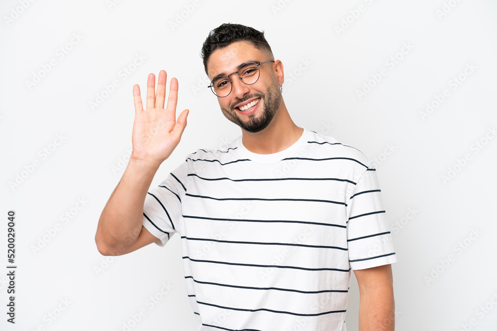 Young Arab handsome man isolated on white background saluting with hand with happy expression Young Arab handsome man isolated on white background saluting with hand with happy expression