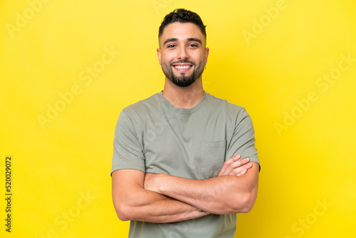 Young Arab handsome man isolated on yellow background keeping the arms crossed in frontal position