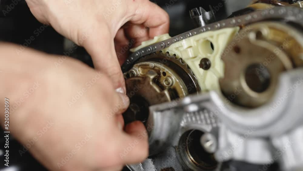 Unrecognizable mechanic repairing automobile motor. Auto master fixing engine from vehicle. Repairer working in garage or workshop. Car mechanic repair the engine