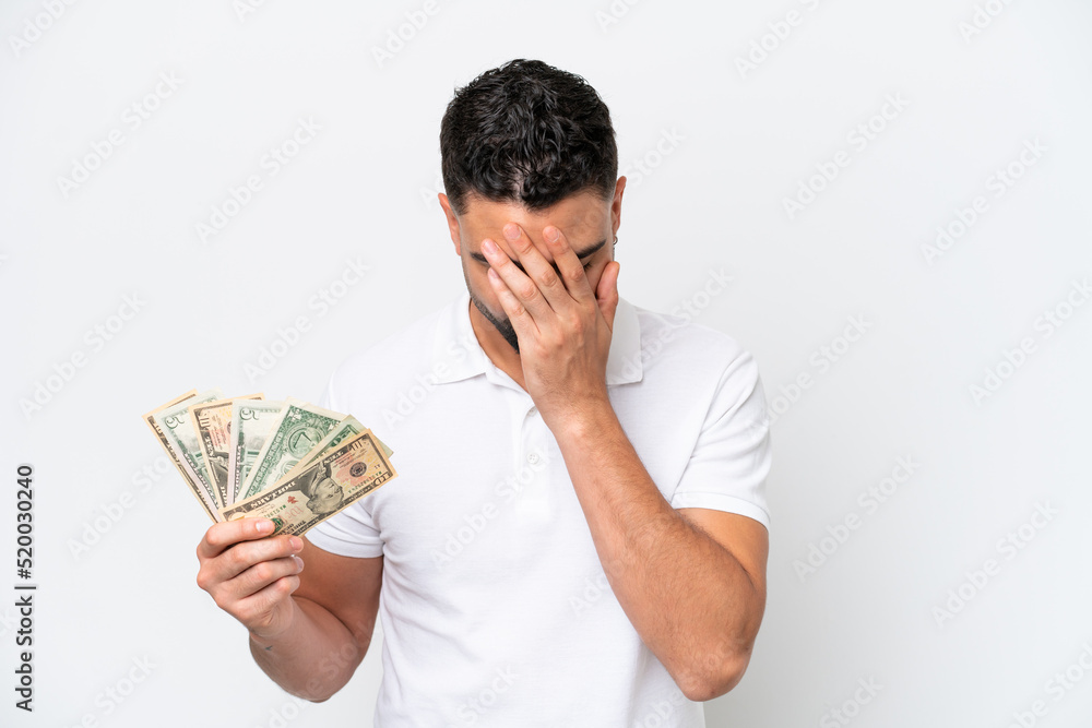 Young Arab man taking a lot of money isolated on white background with tired and sick expression Young Arab man taking a lot of money isolated on white background with tired and sick expression