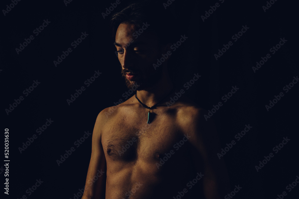 young latin man slim and tanned shirtless, studio picture