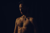 young latin man slim and tanned shirtless, studio picture