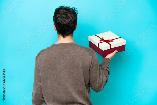 Young man holding a gift in back position