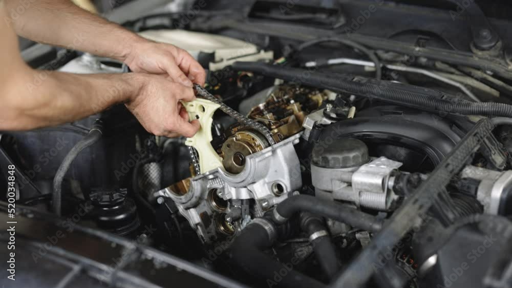 Unrecognizable mechanic repairing automobile motor using tool. Car mechanic repair the engine in a car service. Auto master fixing engine from vehicle. Repairer working in garage or workshop Unrecognizable mechanic repairing automobile motor using tool. Car mechanic repair the engine in a car service. Auto master fixing engine from vehicle. Repairer working in garage or workshop