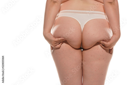 a chubby woman raises her ass with her hands photo