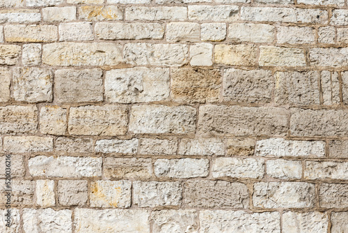 ściana z kamienia w średniowiecznym klimacie o bezowej kolorystyce.