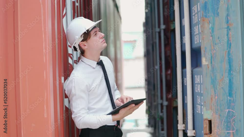 Dock manager man or engineer worker looking at tablet and inspector container in shipping yard with smile. Import and export product. Manufacturing transportation and global business concept