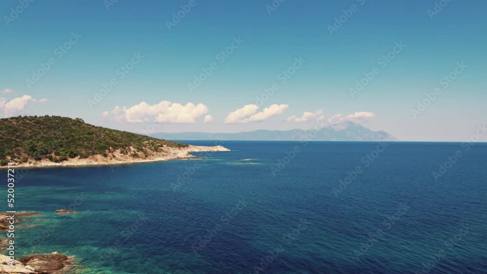 Paralia Acheada, Greece. Beautiful vivid blue and turquoise seashore of a Greek island. Rocky beaches. Amazing weather with blue sky and few fluffy clouds. High quality 4k footage Paralia Acheada, Greece. Beautiful vivid blue and turquoise seashore of a Greek island. Rocky beaches. Amazing weather with blue sky and few fluffy clouds. High quality 4k footage