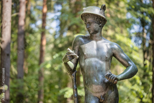 Hermes of Florence (Mercury) in the palace park of the Russian Tsar Paul I in summer, Pavlovsk, Russia. A bronze copy (18th century) of an antique marble statue. The original is in the Vatican.