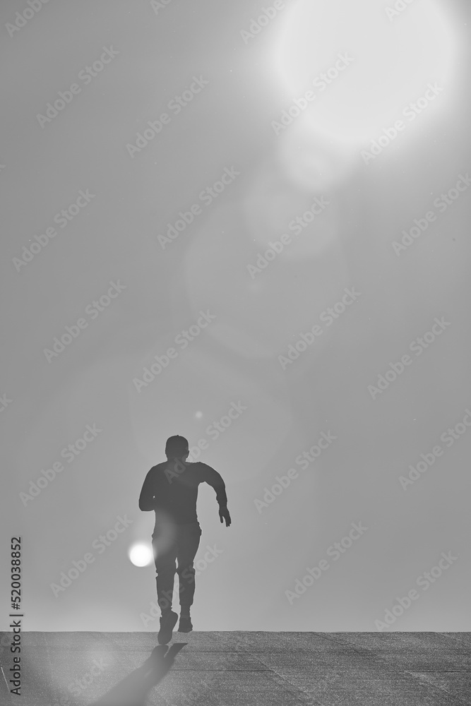 Fototapeta premium man running towards the sun during sunset