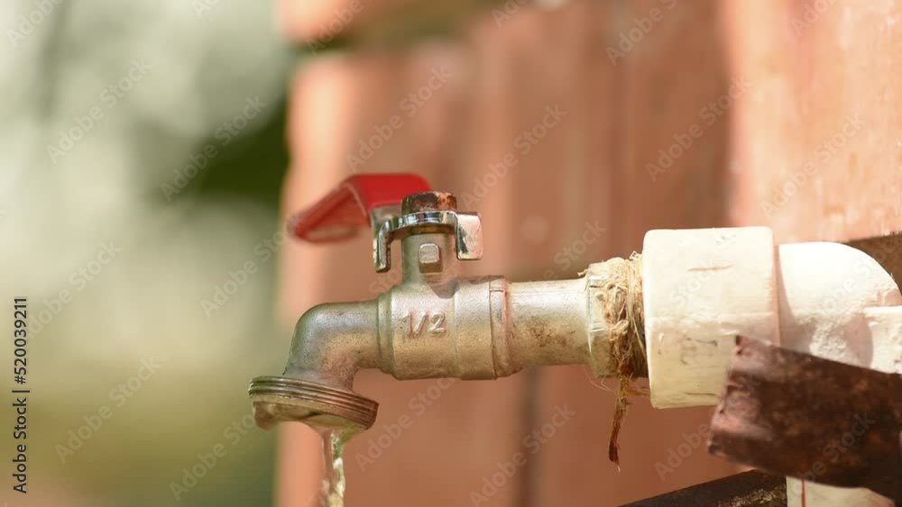 Back yard garden spigot faucet with dripping water Back yard garden spigot faucet with dripping water