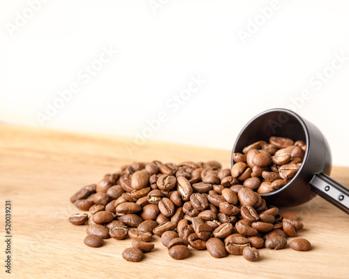 Coffee beans spilling from scoop