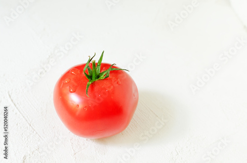 One red ripe tomato on a white background. Healthy food concept. Horizontal orientation. Selective focus. copy space.