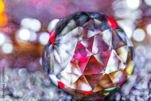 Closeup of crystal glass faceted ball on background of festive lights. Abstract festive, christmas or interior background. Christmas decoration.