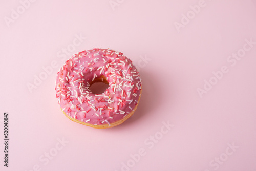 pink glazed donut with confectionery sprinkles