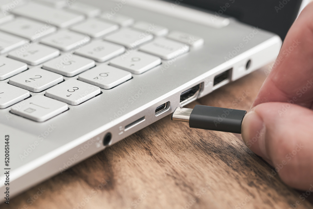 insert USB type c plug into USB port on laptop computer Stock Photo