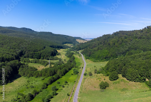 landscape of a road among hills and forests seen from above