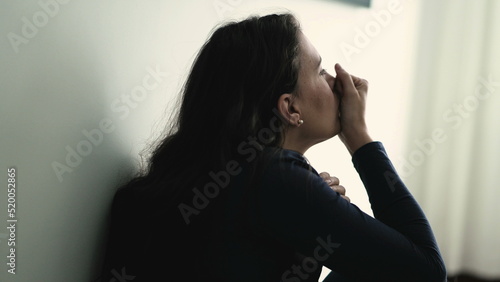 Troubled woman suffering alone with anxiety sitting on floor at home. Anxious person