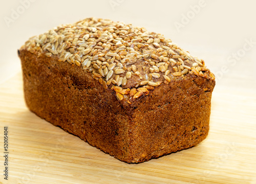 Rectangular bread. Black rye bread with sunflower seeds on a wooden table.