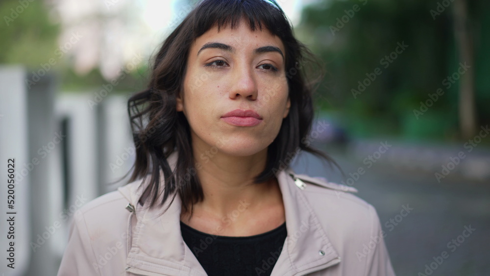 Pensive young woman walking outside in street. One thoughtful hispanic latin person walks in contemplation Pensive young woman walking outside in street. One thoughtful hispanic latin person walks in contemplation