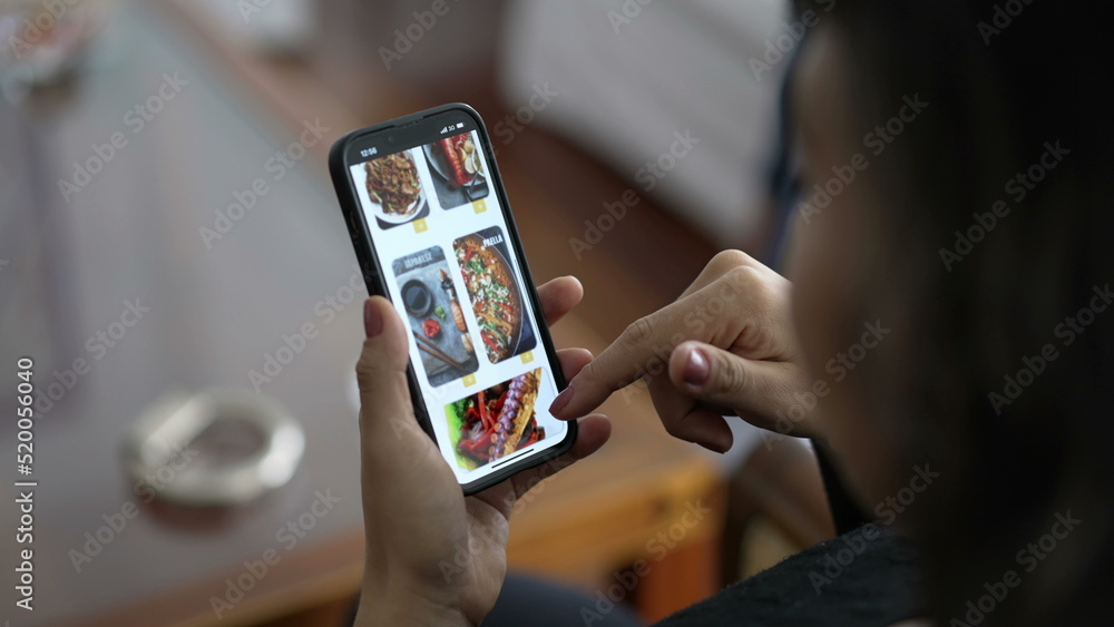 Closeup hands browsing online food app menu searching what to eat. Female hand searching for food