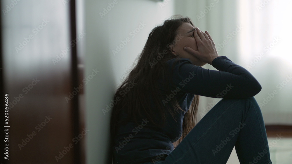 Anxious woman sitting on floor suffering from mental illness at home. Lonely person feeling despair and hopelessness Anxious woman sitting on floor suffering from mental illness at home. Lonely person feeling despair and hopelessness