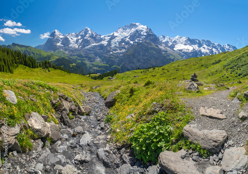 The panorma of Bernese alps with the Jungfrau, Monch and Eiger peaks with the little creek. photo