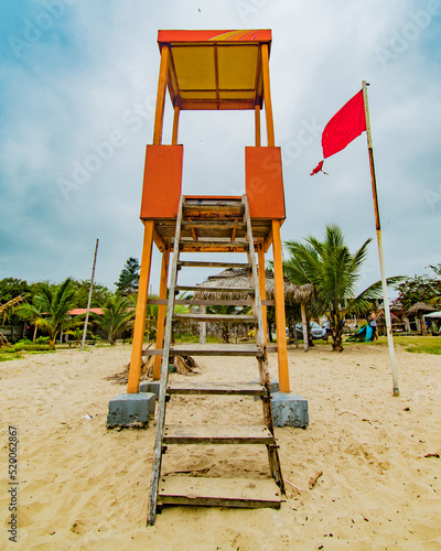 SILLA DE SALVA VIDAS CON BANDERA ROJA CON DIA SOLEADO