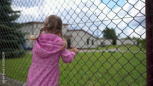Closeup Child boy hand holding steel fence. Rear view.Concept for child abuse, human trafficking, crime and domestic violence,protection of kid.
