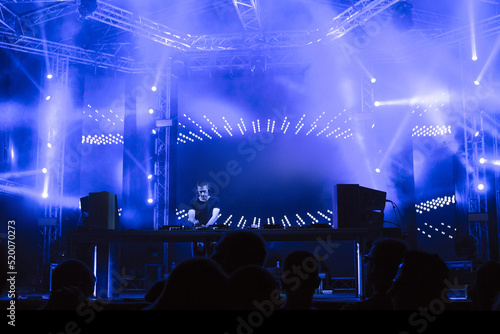 Dj playing techno music on the night concert in summer