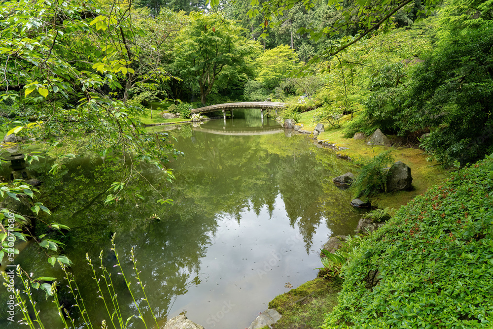 A bridge and reflection pond in the Nitobe Memorial Botanical Garden, Vancouver, BC, British Columbia, Canada A bridge and reflection pond in the Nitobe Memorial Botanical Garden, Vancouver, BC, British Columbia, Canada