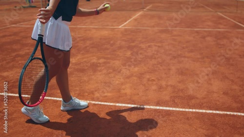 Concept of professional sport and healthy lifestyle closeup to the camera tennis player woman hitting the ball on the floor then hit hard the ball with the racket outdoor on the tennis court