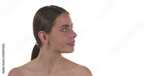 Portrait of a brunette caucasian woman turning her head to the side and looking. Isolated on a white background.