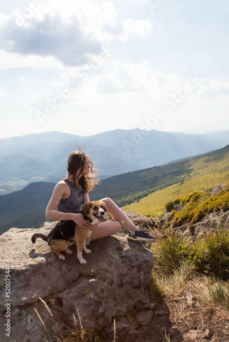 young woman with a dog in the mountains on a hike