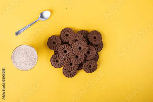 Bolacha biscoito de chocolate caseiro na forma de flor isolado em fundo amarelo photo