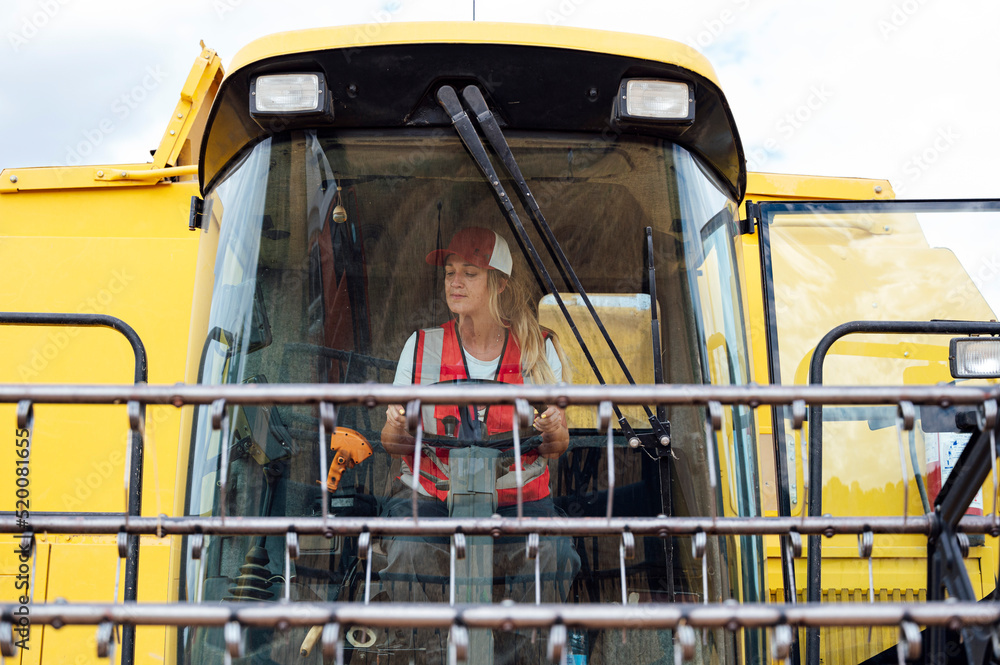 © ADDICTIVE STOCK - Woman driving industrial combine harvester