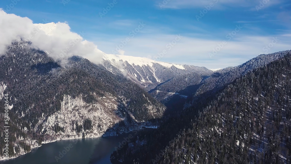 Obraz premium Panoramic view of beautiful white winter wonderland scenery with snowy mountain summits. Clip. Cold sunny day with blue sky and clouds