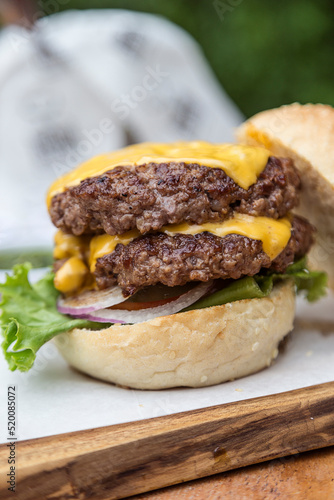 Double cheeseburger with onions, tomato, lettuce and cheddar cheese