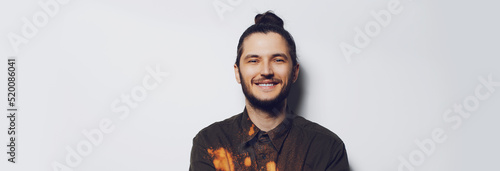 Panoramic banner portrait of young happy hipster on white background with copy space. © Lalandrew