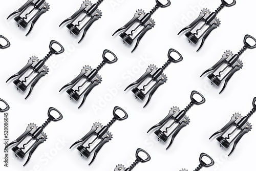 Pattern of wine openers of black color on white background. photo