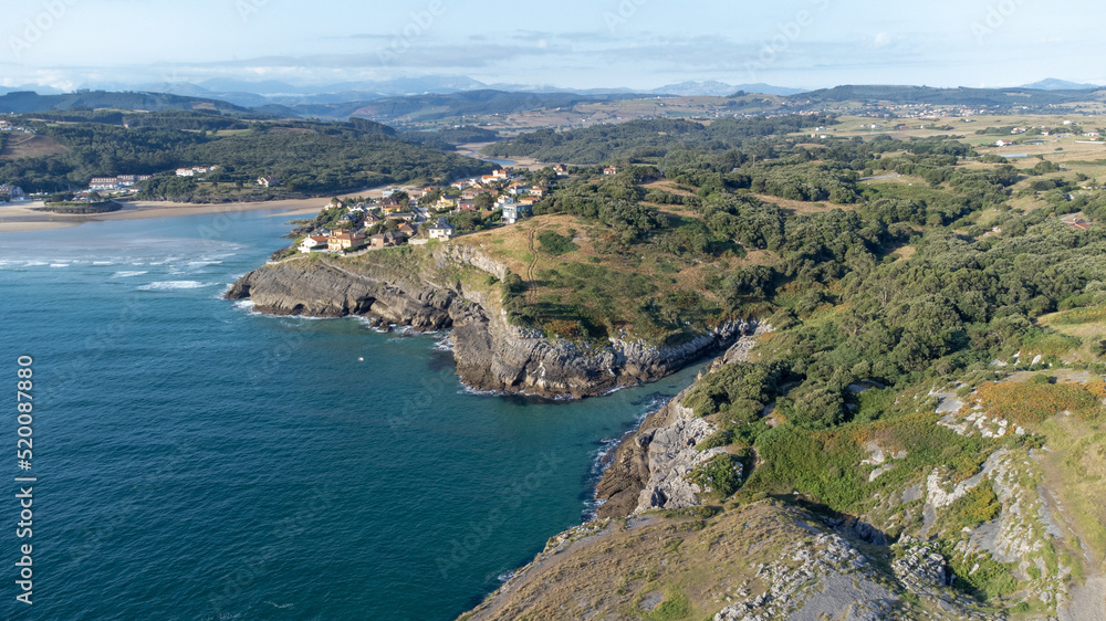 drone aerial view of the cantabrian coast with the village and the beach in the background on a sunny summer day.