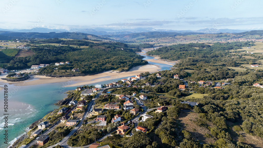 drone aerial view of the cantabrian coast with the village and the beach in the background on a sunny summer day.